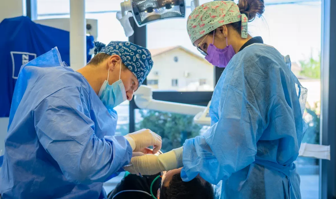 Chirurgie Dentară Fără Durere și Fără Sângerare: Tehnologia SiroLaser Blue Medicii Dental CATTED Dr. Catalin Dumitru si Dr. Ioana Cobalas executand un tratament de chirurgie orala.